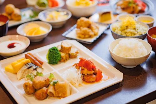 a table with plates of food and bowls of food at Hotel Wing International Kumamoto Yatsushiro in Yatsushiro
