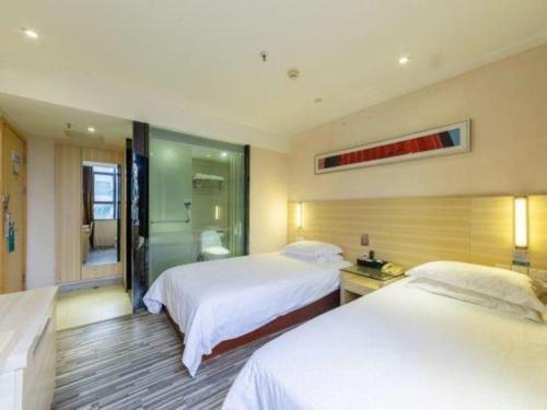 徐闻City Comfort Inn Zhanjiang Xuwen Port Wharf Chengdong的有两张床和一间浴室的酒店房间