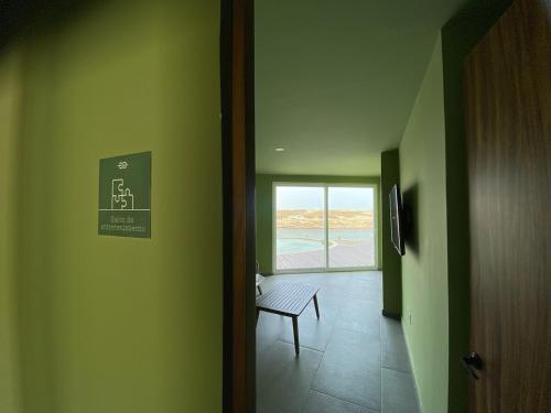 a hallway with a door with a bench and a window at Oceanfront &6pers &Pool &Gym &Golf Club in Boca del Río