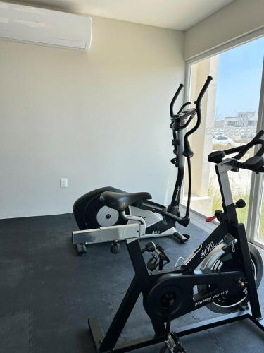 a gym with a treadmill and a bike in a room at Oceanfront &6pers &Pool &Gym &Golf Club in Boca del Río