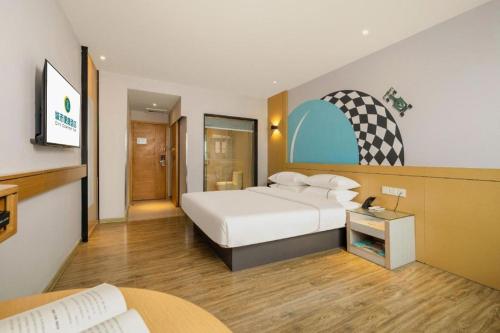 a hotel room with a bed and a tv at City Comfort Inn Liuzhou Baisha Bus Station Shengli Barbecue City in Liuzhou