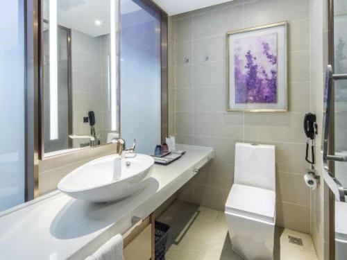 a bathroom with a sink and a toilet at Lavande Hotels· Yueyang Linxiang Zhongfa in Linxiang
