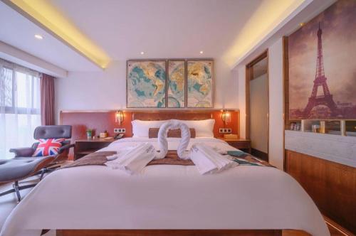 a bedroom with a large white bed with the eiffel tower at James Joyce Coffetel Wuhan Gutian Er Road Metro Station in Wuhan
