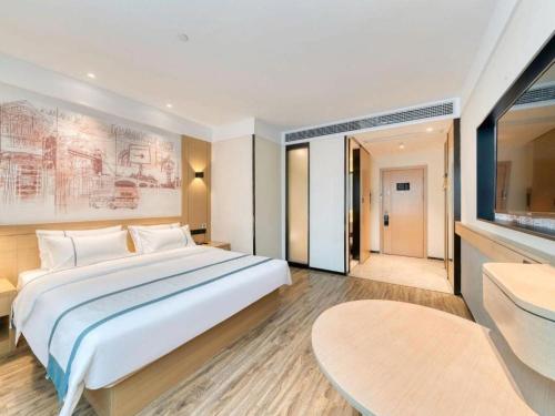 a bedroom with a large bed and a large window at City Comfort Inn Lijiang Ancient Town in Lijiang