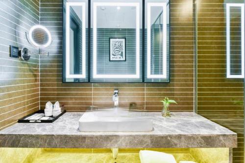 a bathroom with a sink and a mirror at Xana Hotelle Wuxi Railway Station Zhongshan Road in Wuxi