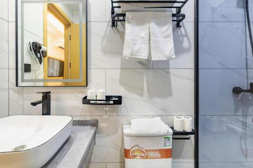 a white bathroom with a sink and a mirror at GreenTree Inn Express Shanghai Baoshan District Youyi Road Metro Station in Baoshan