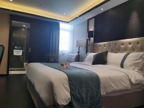 a bedroom with a large bed with a large headboard at Xana Hotelle Wuxi Railway Station Zhongshan Road in Wuxi