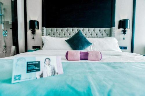 a bedroom with a bed with a picture of a child on it at Xana Hotelle Wuxi Railway Station Zhongshan Road in Wuxi