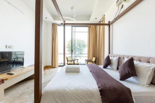 a bedroom with a large bed and a television at Heartland- Ganga Villa with Jacuzzi and private lift in Rishīkesh