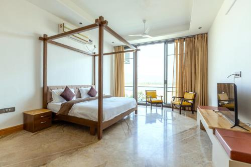 a bedroom with a canopy bed and a living room at Heartland- Ganga Villa with Jacuzzi and private lift in Rishīkesh