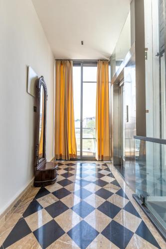a room with a checkered floor and yellow curtains at Heartland- Ganga Villa with Jacuzzi and private lift in Rishīkesh