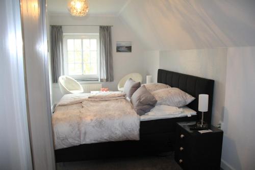 ein Schlafzimmer mit einem großen Bett und einem Fenster in der Unterkunft Pension Nordwind in Hedwigenkoog