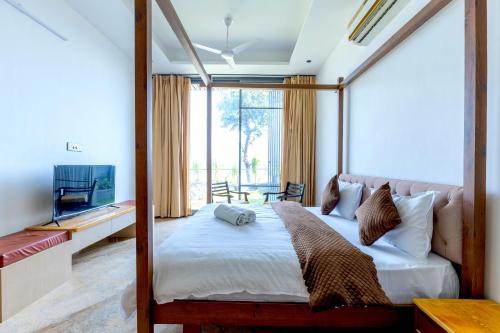 a bedroom with a four poster bed and a television at Heartland- Ganga Villa with Jacuzzi and private lift in Rishīkesh