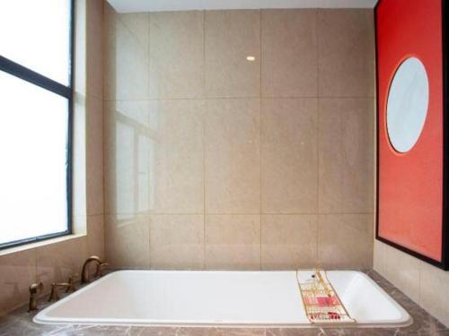a large white tub in a bathroom with a window at E-Cheng Hotel Yangjiang Baili Plaza in Yangjiang