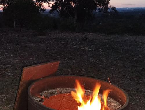 a fire pit with flames in it in a field at Barossa Views Homestay in Barossa