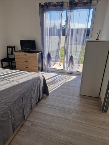 une chambre avec un lit et une grande fenêtre dans l'établissement Maison caroline 1, à La Celle-sous-Gouzon