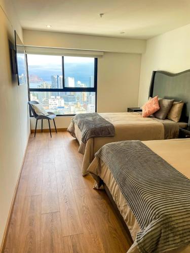 a hotel room with two beds and a large window at Ocean view 1 BR Miraflores with parking in Lima