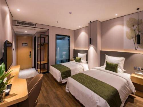 a hotel room with two beds and a desk at Green Tree Inn Express Fuzhou Three Lanes and Seven Alleys Nanmendou Metro Station in Fuzhou