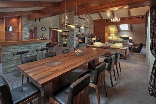 a dining room with a large wooden table and chairs at Kempinski Hotel Grand Arena Bansko in Bansko