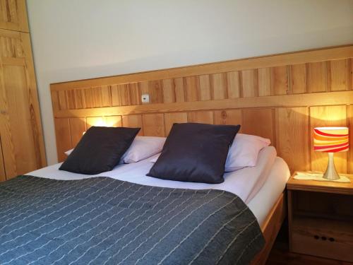 a bedroom with a bed with two pillows and a lamp at Govc-Vršnik in Solčava