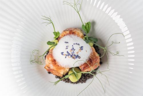 a white plate with a dish with food on it at Kempinski Hotel Grand Arena Bansko in Bansko