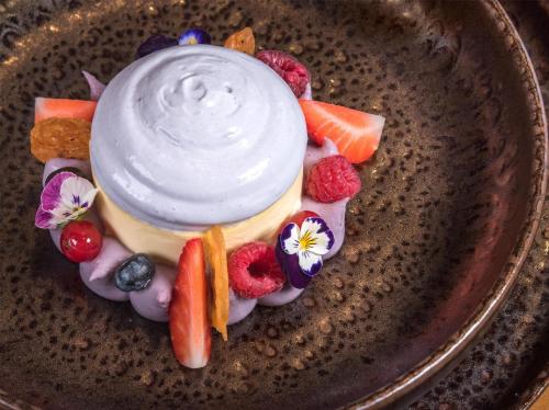 a plate with a dessert with yogurt and fruit at Kempinski Hotel Grand Arena Bansko in Bansko