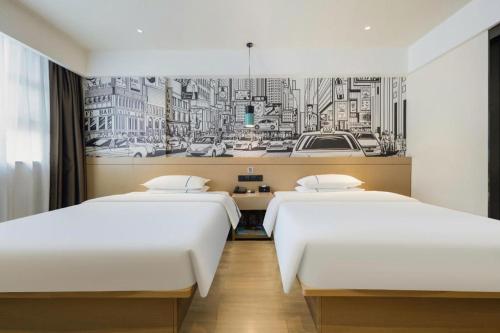 two beds in a hotel room with a drawing on the wall at City Comfort Inn Wuzhou Sun Plaza Wanda in Wuzhou