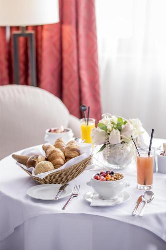 a table with breakfast foods and drinks on it at Kempinski Hotel Grand Arena Bansko in Bansko