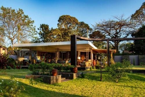 a house in a garden with trees in the background at Kinga Homes Boutique Hotel in Moshi