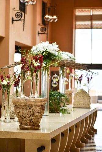 a table with vases filled with flowers on it at Kempinski Hotel Ishtar Dead Sea in Sowayma