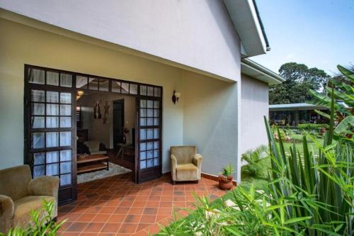 a patio of a house with two chairs and a door at Kinga Homes Boutique Hotel in Moshi
