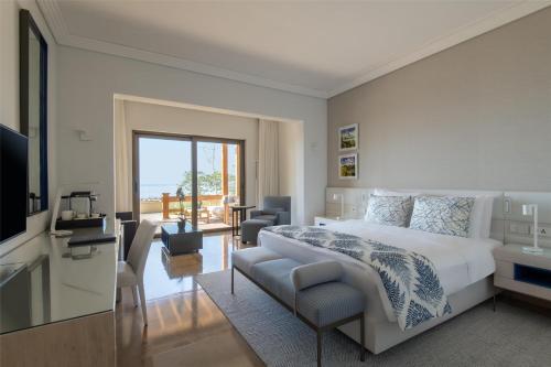 a bedroom with a bed and a living room at Kempinski Hotel Ishtar Dead Sea in Sowayma
