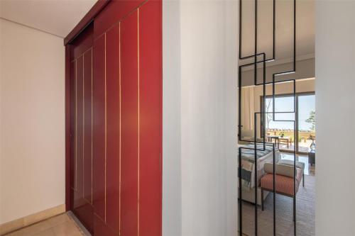 a red door in a room with a dining room at Kempinski Hotel Ishtar Dead Sea in Sowayma