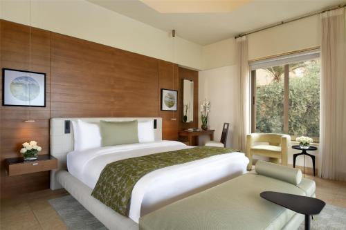 a hotel room with a large bed and a window at Kempinski Hotel Ishtar Dead Sea in Sowayma