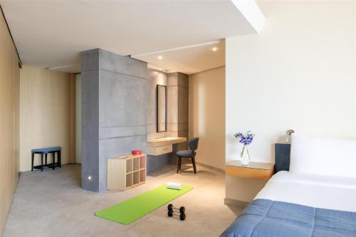 a bedroom with a bed and a green rug at Kempinski Hotel Ishtar Dead Sea in Sowayma
