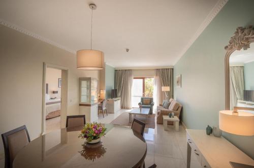 a living room with a table and a dining room at Kempinski Hotel San Lawrenz in San Lawrenz