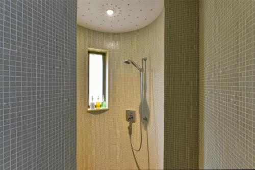 a bathroom with a shower with a window at Kempinski Hotel Ishtar Dead Sea in Sowayma