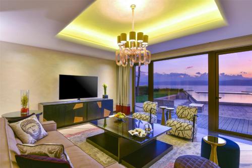 a living room with a chandelier and a living room at Kempinski Hotel Ishtar Dead Sea in Sowayma