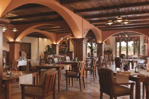 a restaurant with tables and chairs in a room at Kempinski Hotel San Lawrenz in San Lawrenz