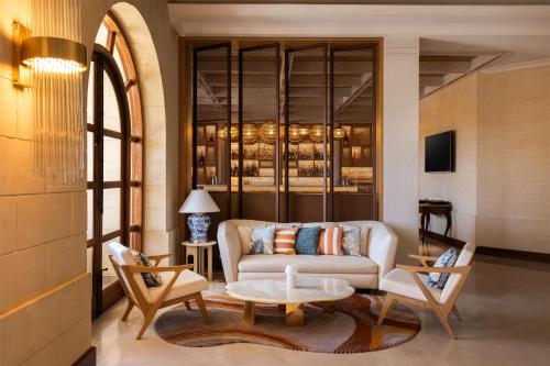 a living room with a couch and a table at Kempinski Hotel San Lawrenz in San Lawrenz