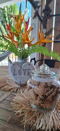 a table with two vases filled with shells and flowers at Kot Nou - Kwizine Mama Manze Lakaz in Mahébourg