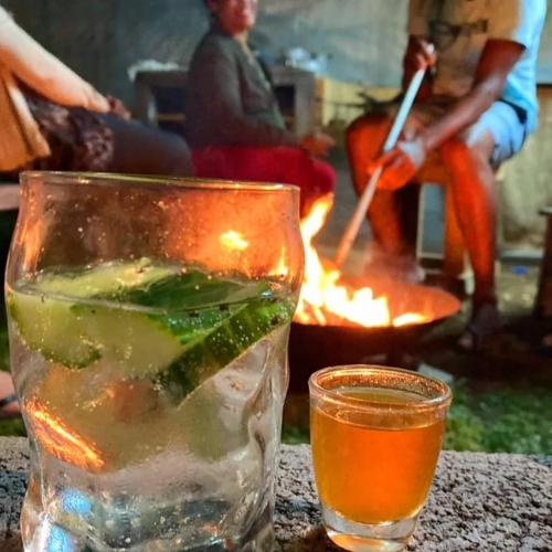 a glass of water and a drink on a table at Kot Nou - Kwizine Mama Manze Lakaz in Mahébourg