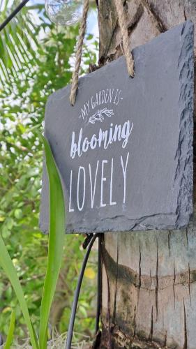 a sign that says my garden is blooming lovely at Kot Nou - Kwizine Mama Manze Lakaz in Mahébourg
