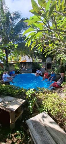 a group of people sitting around a swimming pool at Kot Nou - Kwizine Mama Manze Lakaz in Mahébourg