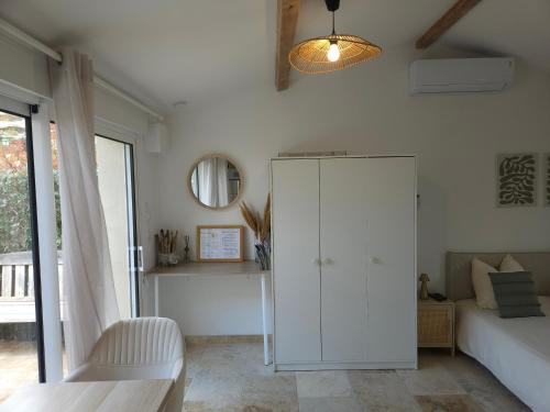 a bedroom with a white cabinet and a bed at Havre de paix climatisé vers Gordes - Spa & nature in Beaumettes