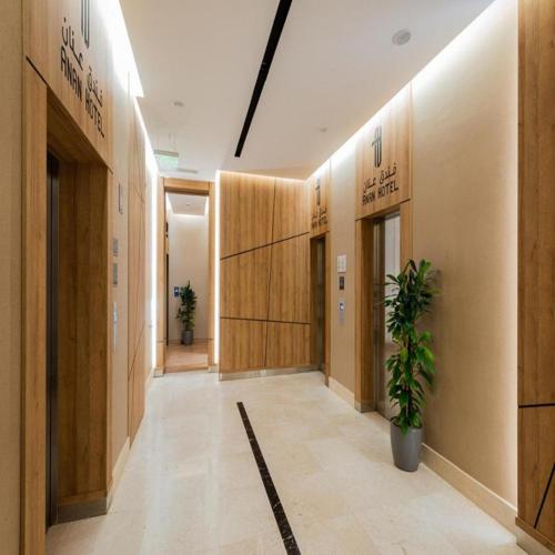 a hallway with wooden walls and a potted plant at Sunday Luxury Central formerly Anan hotel in Riyadh