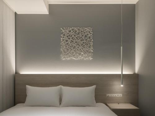 a bedroom with a bed and a painting on the wall at HOTEL FORZA SAPPORO STATION in Sapporo