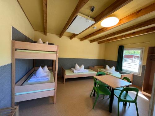 a room with two bunk beds and a table at KiEZ Am Braunsteich Weißwasser in Braunsteich