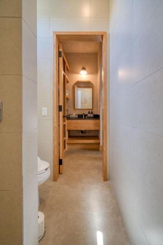 a bathroom with a toilet and a sink and a mirror at Casa Olivea in Valle de Guadalupe