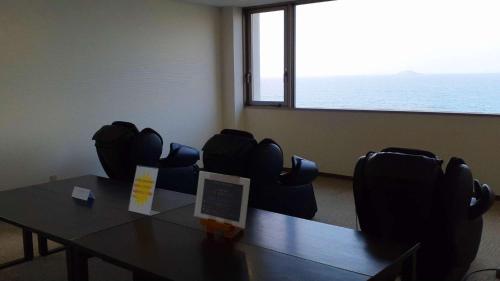 a conference room with a table and chairs with a large window at Marine Hotel Harimo in Hamada